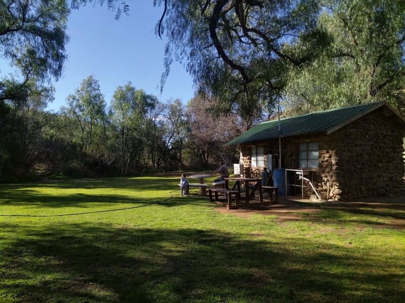 Stone building with green lawn at Red Dune Camp